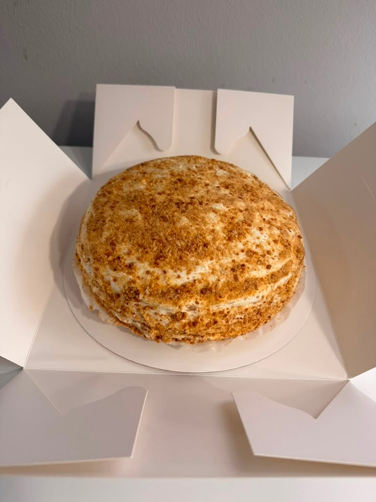 Handmade Russian Medovik honey cake in an open white presentation box